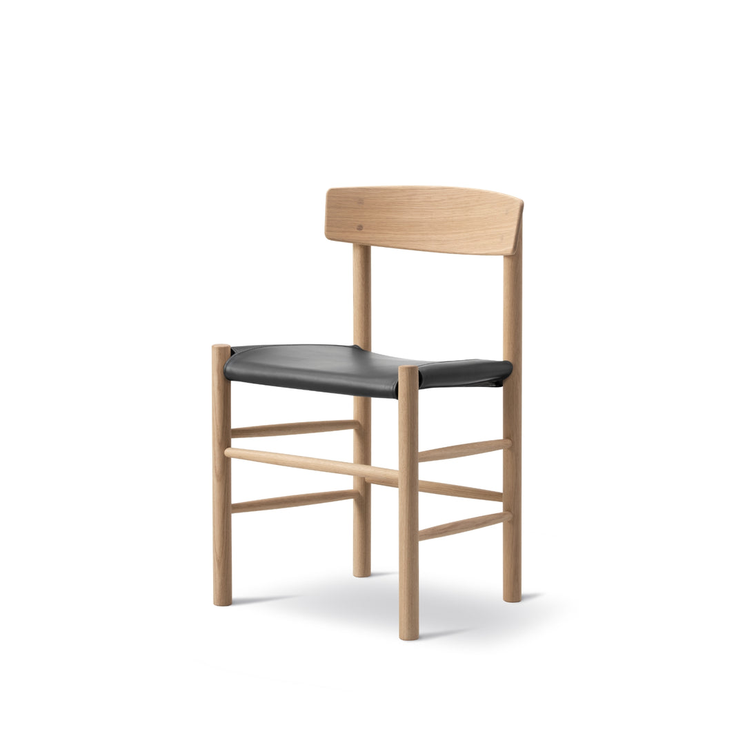 J39 Folkstolen designet af Børge Mogensen, sædepolstret med sort læder i eg sæbe