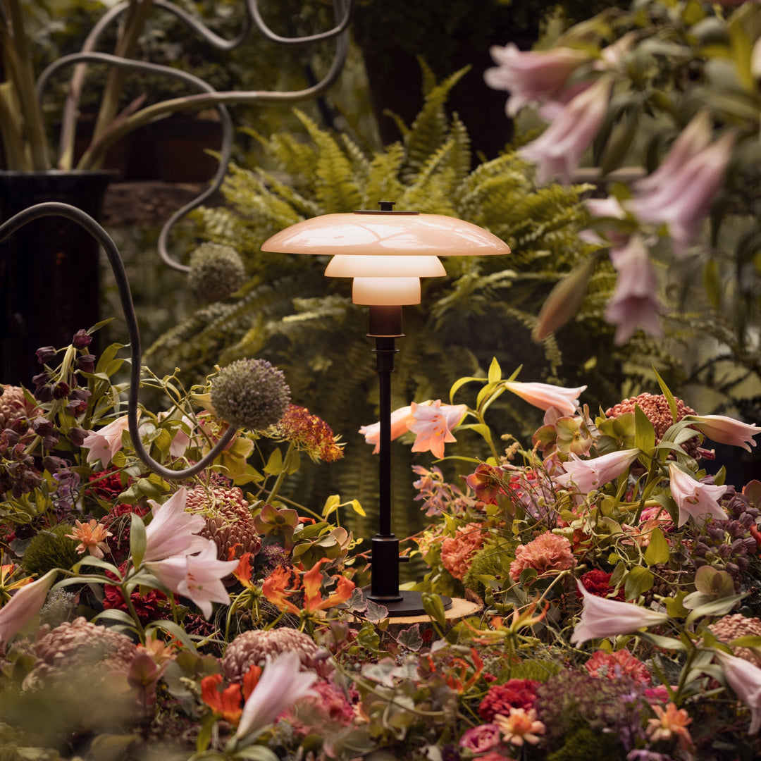 PH 3/2 Dusty Terracotta Limited Edition 2025 fra Louis Poulsen omgivet af blomster