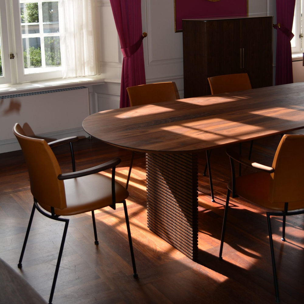 Panther spisebordsstol med armlæn fra Naver Collection. Stolen har ben af rustfrit stål, armlæn i træ og sæde i forskellige farver og sammensætninger.