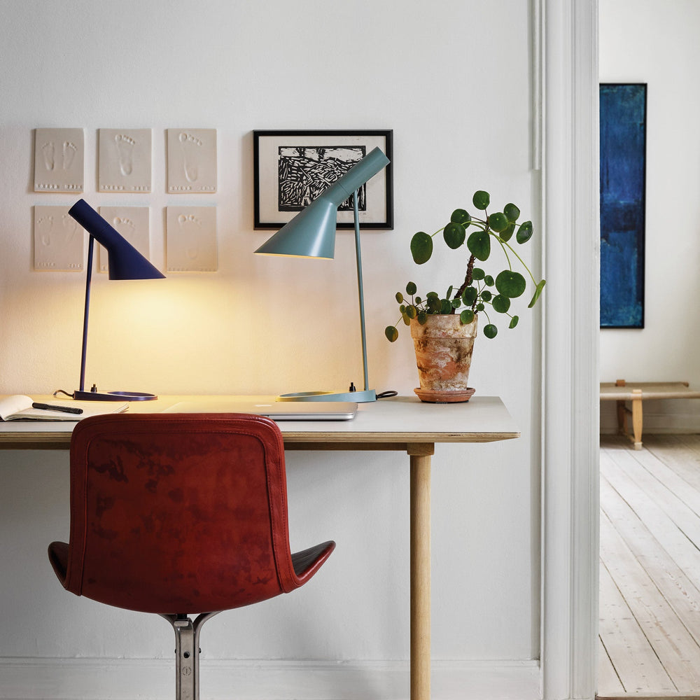AJ mini bordlampe designet af Arne Jacobsen for Louis Poulsen i blå på skrivebord