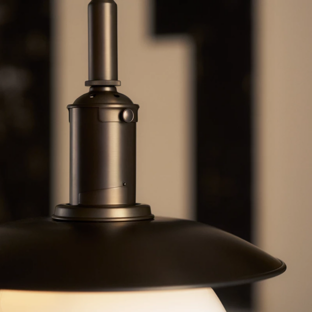 PH 3/3 Aged Brass Opal Pendel er en smuk lampe i bruneret messing fra Louis Poulsen som kan løfte ethvert rum, inklusiv små rum og områder med højt til loftet.