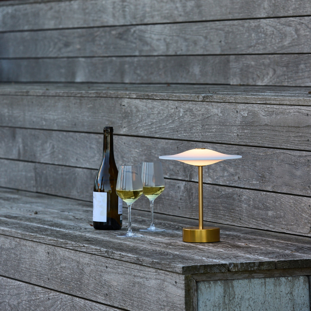 Sinus Portable bordlampe fra Piet Hein i messing på picnic