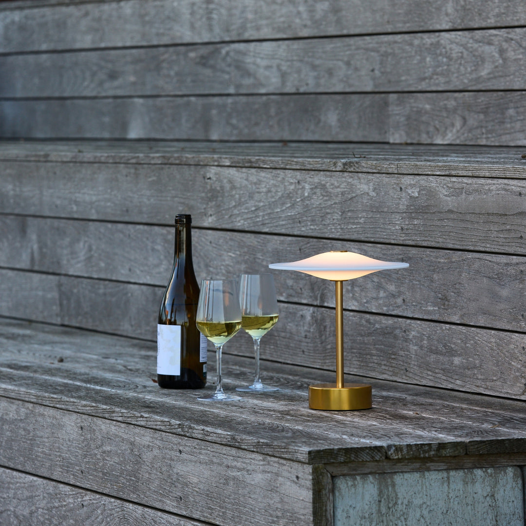 Sinus Portable bordlampe fra Piet Hein i messing på picnic