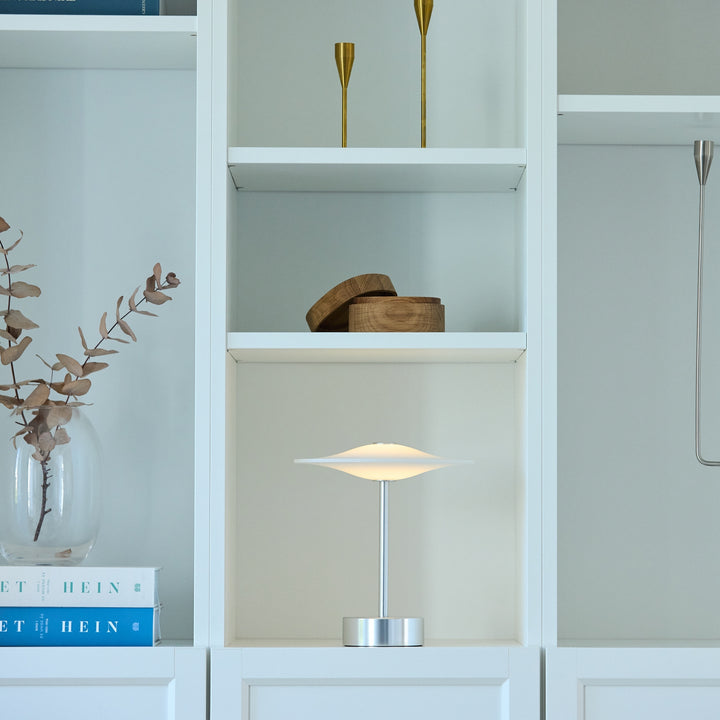 Sinus Portable bordlampe fra Piet Hein i stål i reol i stue