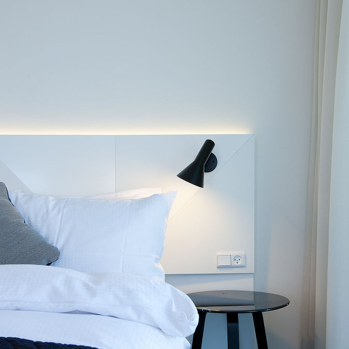 AJ væglampe designet af Arne Jacobsen fra Louis Poulsen i sort i soveværelse